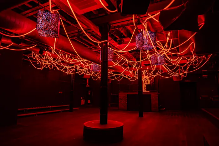 The XOYO basement lit red, looking down the room towards the booth.